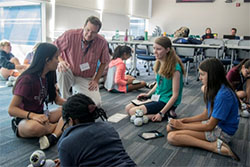 A group of girls sits in a circle to work on a project