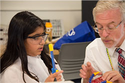 A professor helps a participant in the electrical engineering summer camp