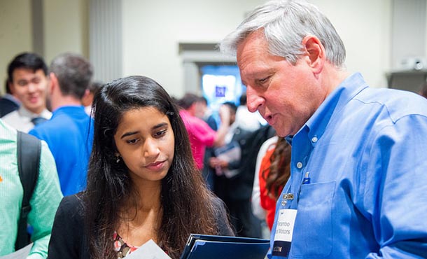 A student and an employer talk at EECS Day