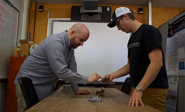 Two researchers examine a piece of equipment