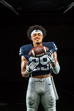 A football player in his uniform with a football