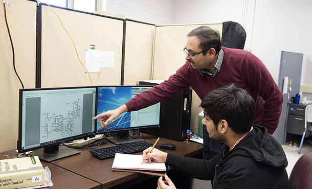 A professor and a student examine a graph on a computer screen