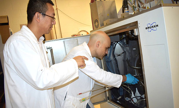 Two researchers operate an MRI machine