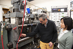Two professors examine lab equipment