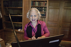 Dr. Yener sits in front of a computer