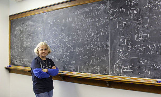 Dr. Yener stands in front of a chalk board